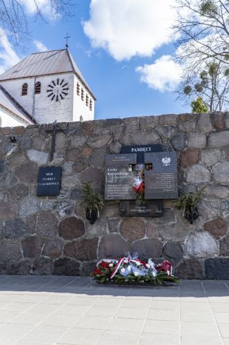 Składanie kwiatów pod murem Pamięci